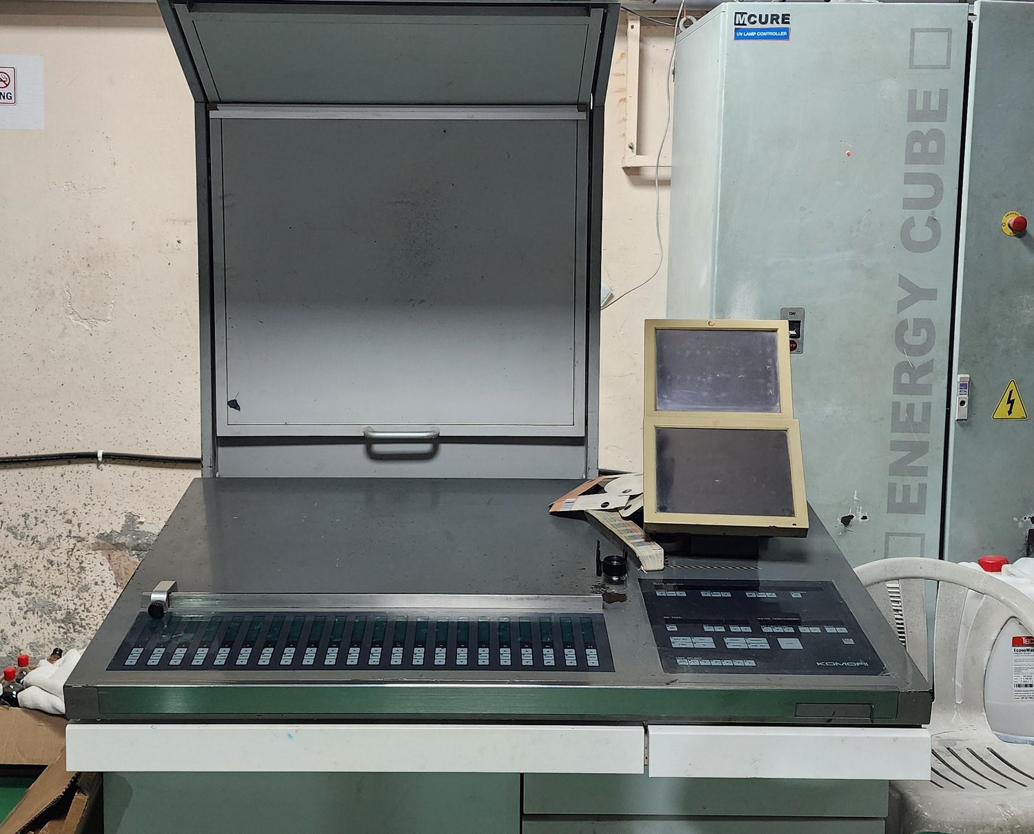 The Komori ink-key console and colour-matching booth beside the M-CURE UV lamp controller and Energy Cube curing unit that give the press its inline UV