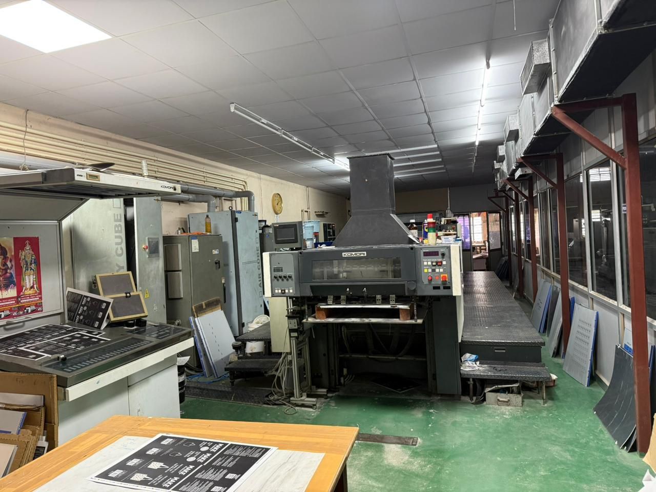 The pressroom at Daffodil Print Media in Karur: the five-colour Komori New Lithrone with its UV curing unit and colour-matching console, printed sheets stacked alongside